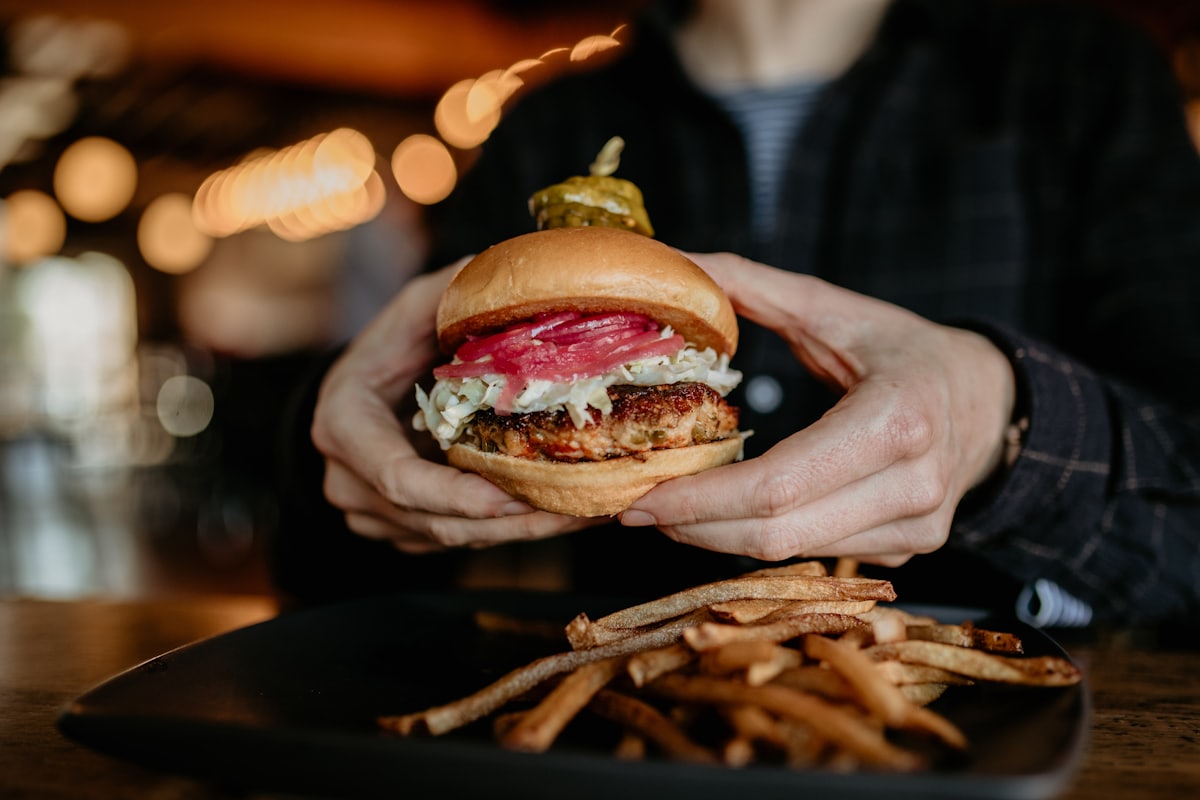 Person hält einen Burger in der Hand